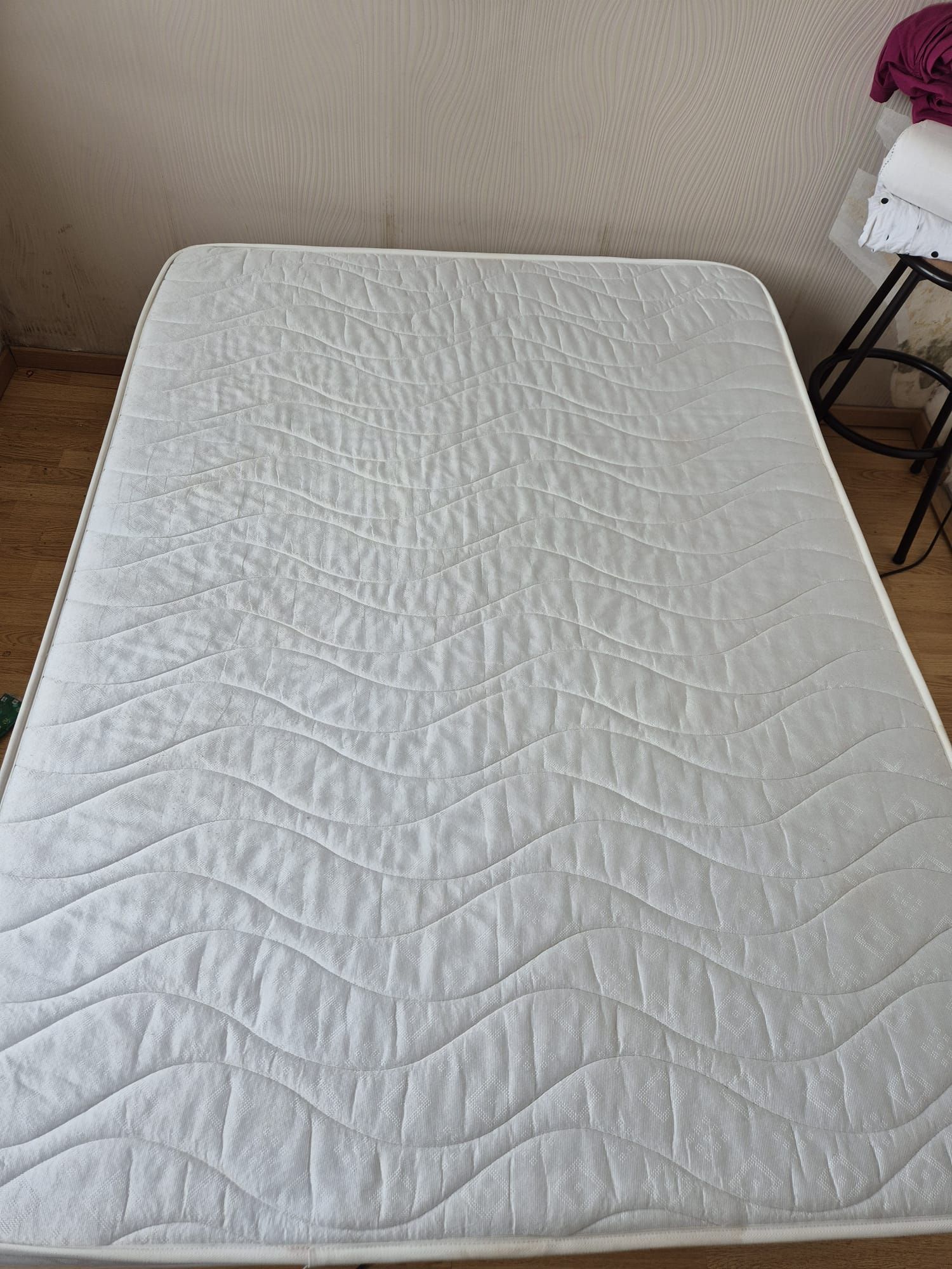 Matelas blanc sur le sol dans une pièce.