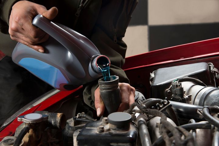 Un garagiste versant de l'huile de moteur