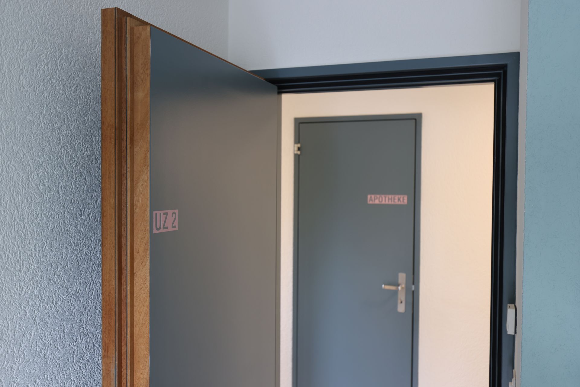 Eine Tür steht offen und führt zu einem Raum. An ihm hängt ein Schild mit der Aufschrift „Umkleideraum“.