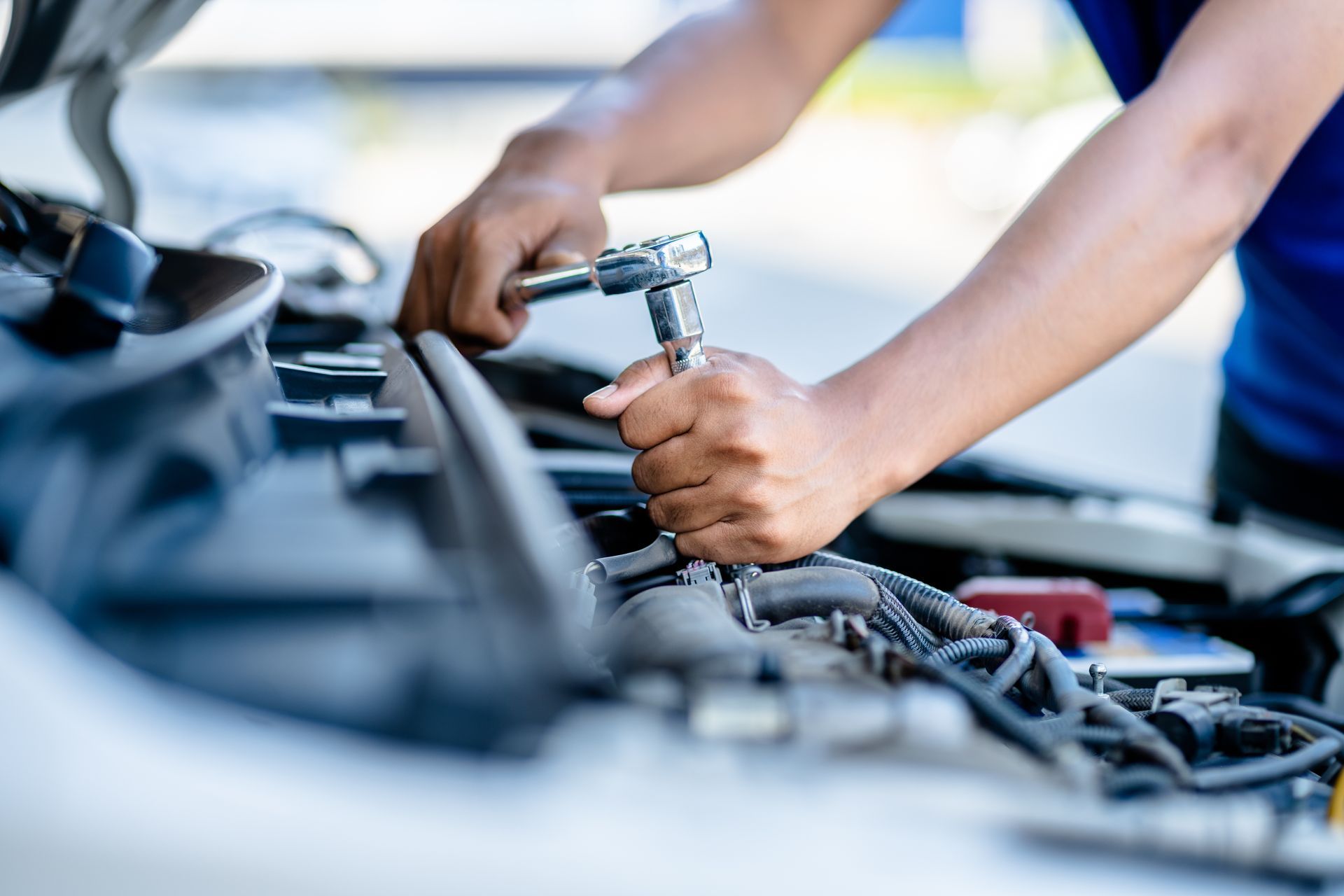 Homme les mains dans un moteur de voiture