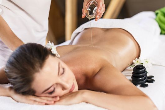 Femme recevant un massage du dos à l'huile, ambiance spa.