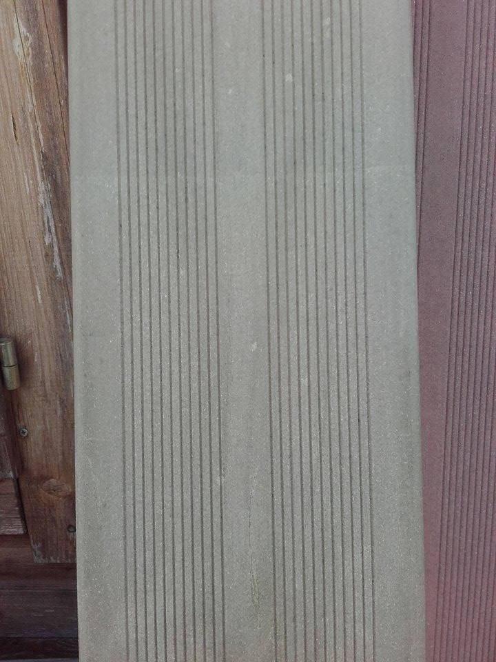 Gros plan vertical d'un bardage beige texturé avec un bord en bois à gauche et une garniture violette à droite