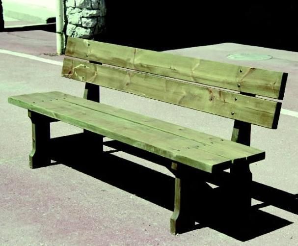 Banc en bois vert patiné sur un trottoir pavé au soleil