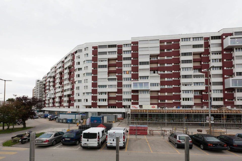 Un grand bâtiment avec des voitures garées devant
