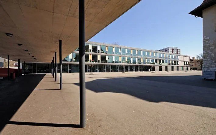 Un grand bâtiment avec une passerelle couverte devant lui