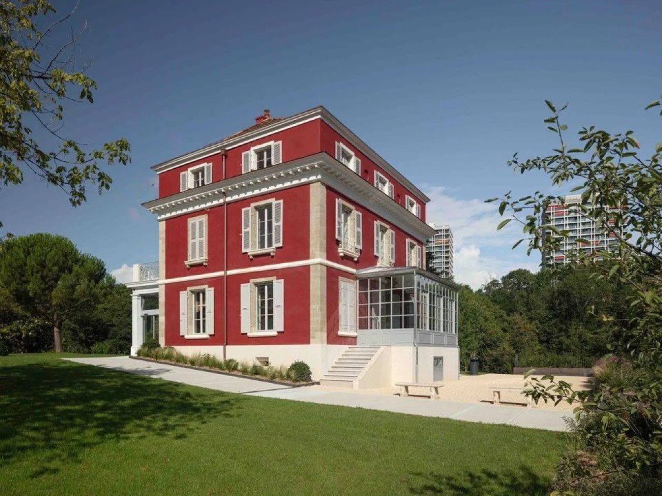 Une grande maison rouge et blanche avec beaucoup de fenêtres