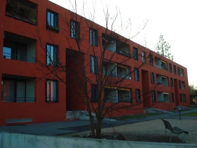 Un bâtiment rouge avec un arbre devant
