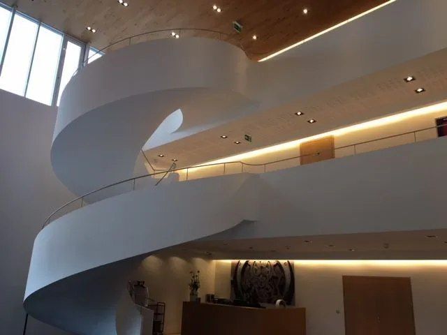 Un escalier en colimaçon dans un bâtiment avec une rampe en bois