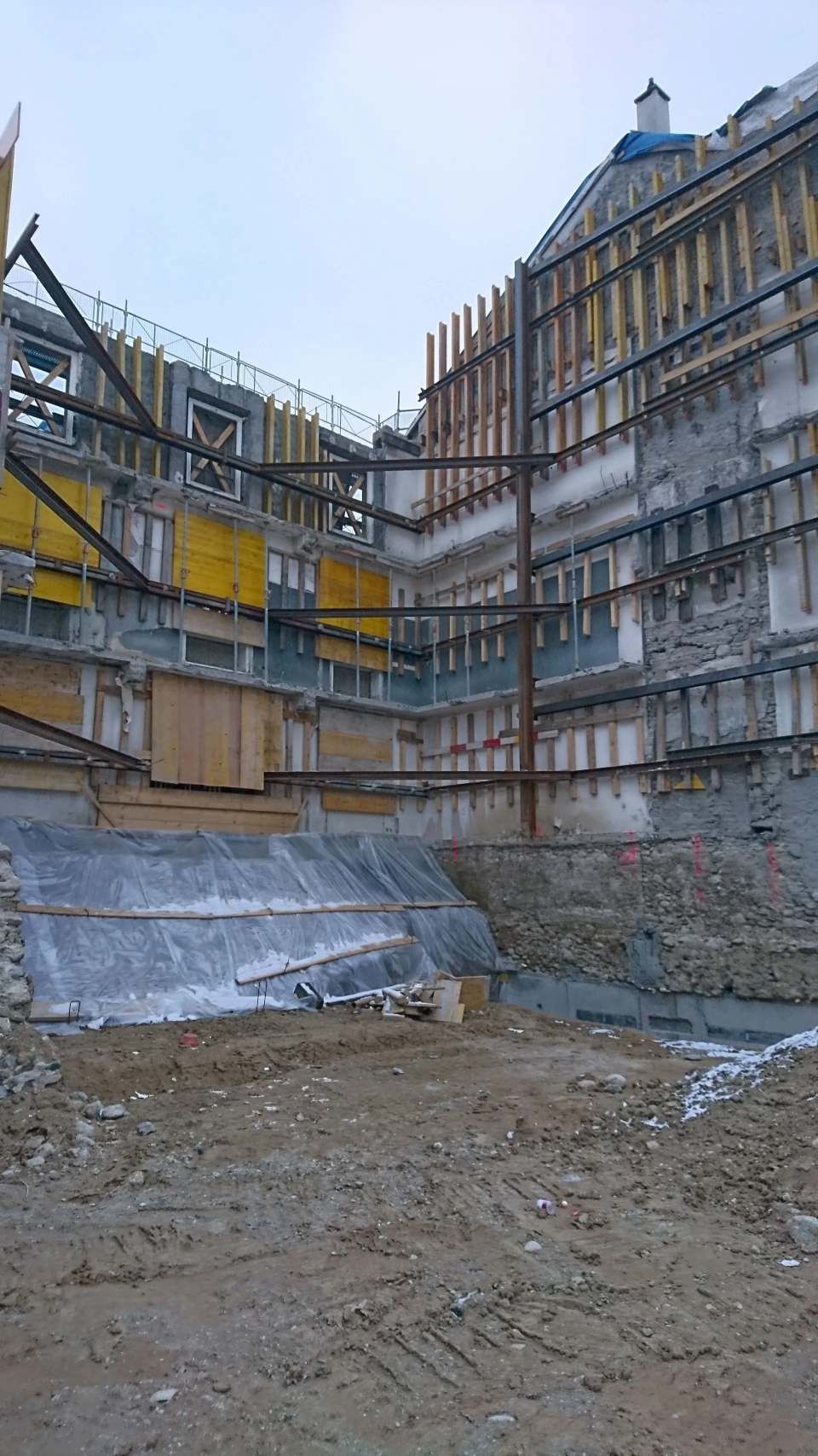 Un grand bâtiment est en construction dans un champ de terre.