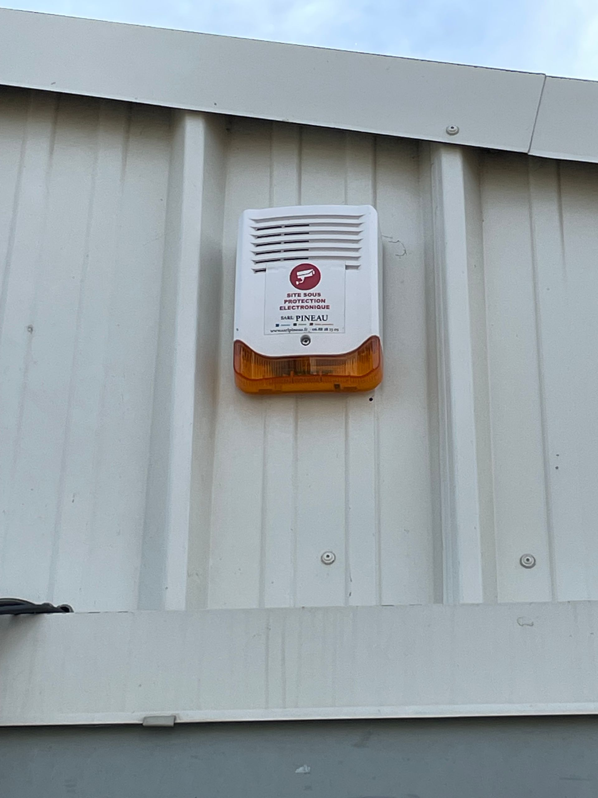 Système d'alarme fixé au mur sur un mur en tôle ondulée blanche