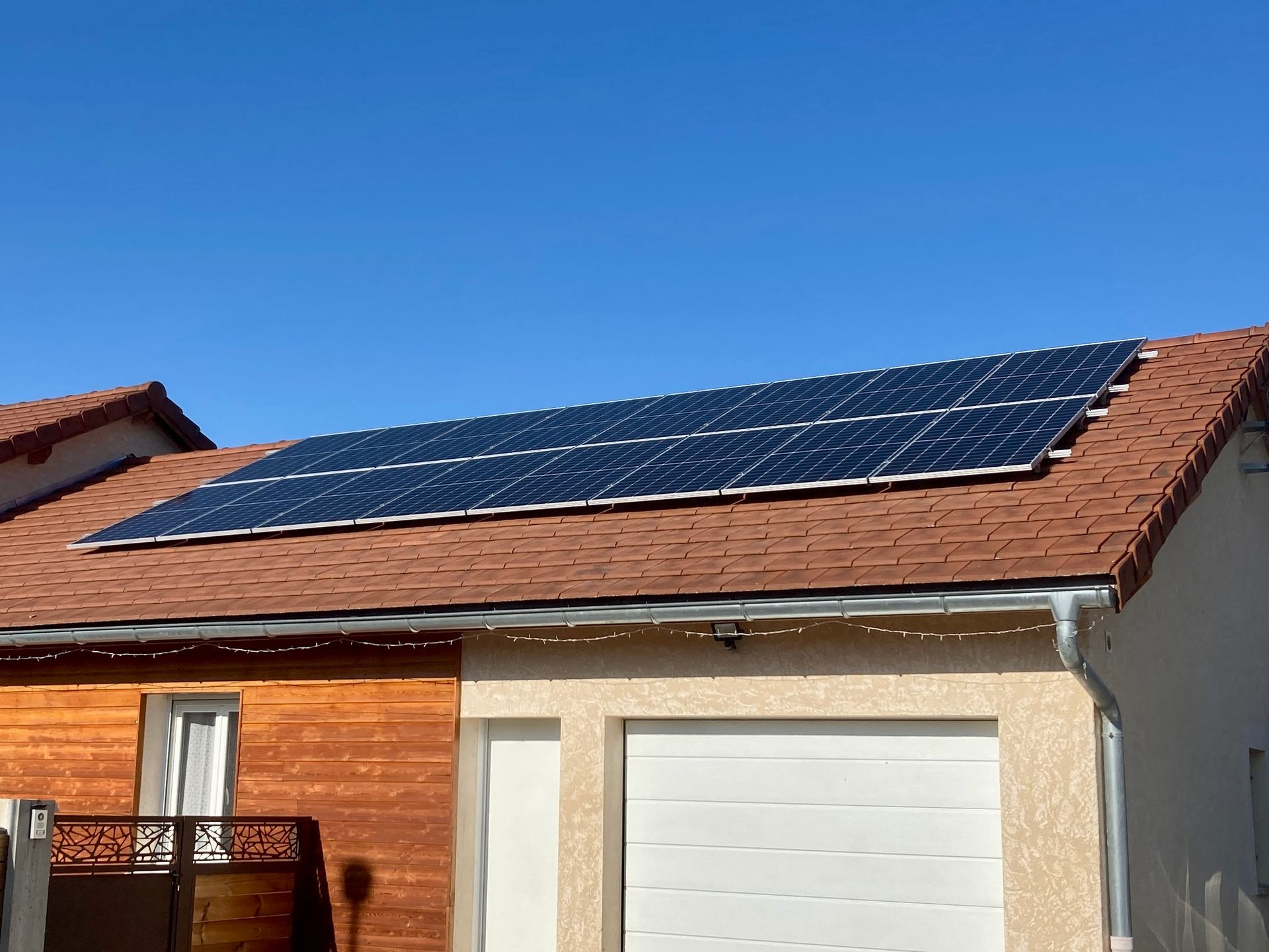 Panneaux photovoltaïques sur un toit au-dessus d'une porte de garage blanche