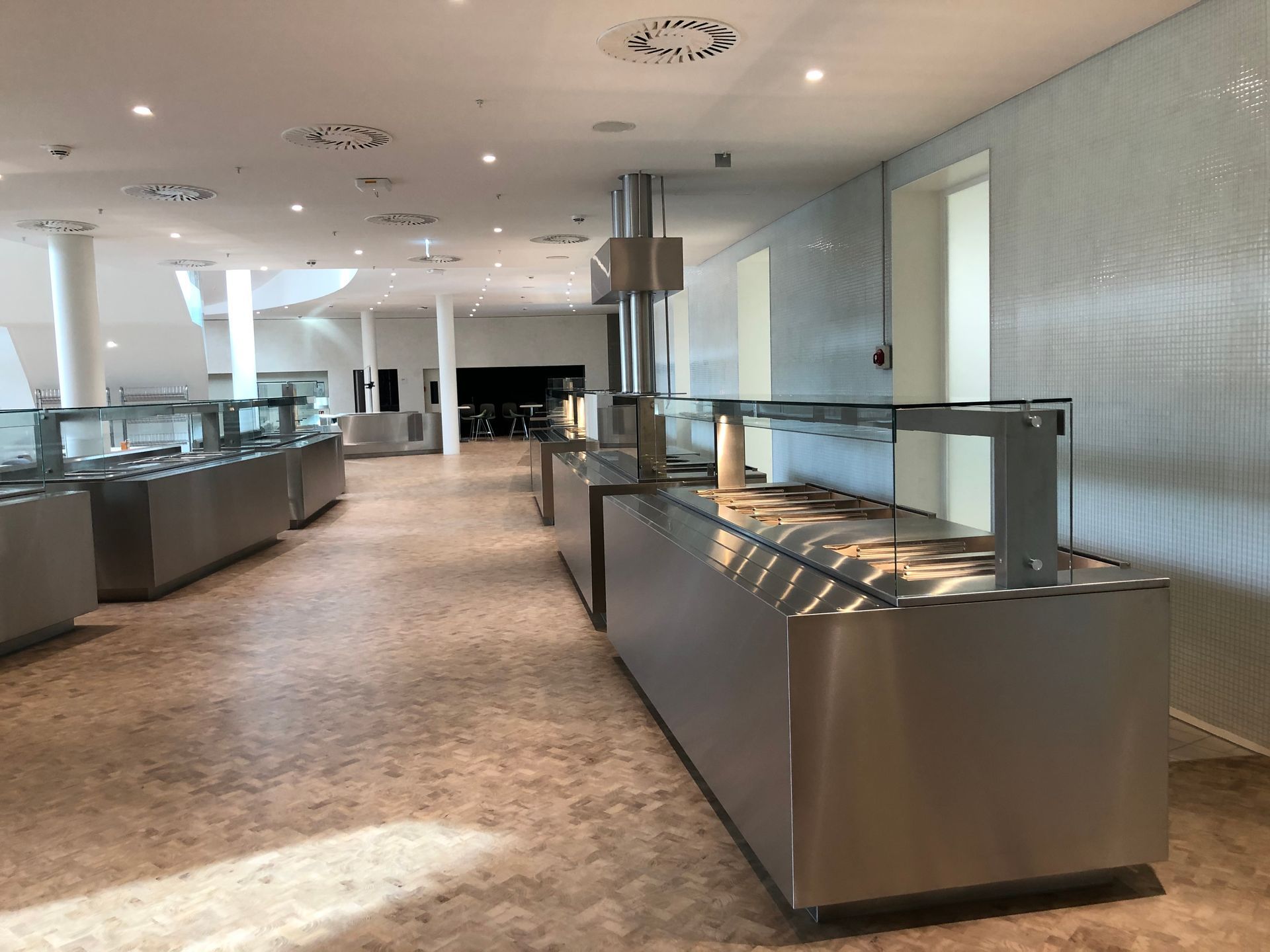 Ein großer Raum mit vielen Buffet-Tischen aus Edelstahl.