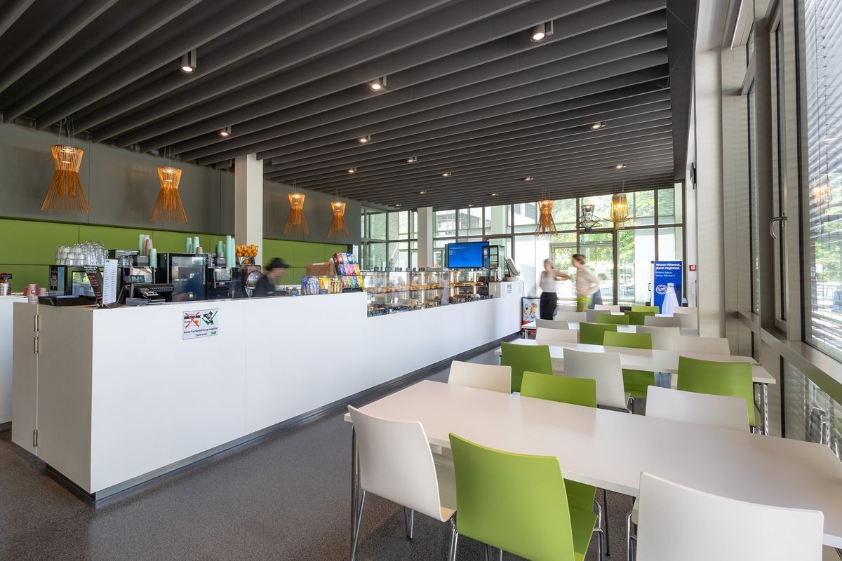 Ein Restaurant mit Tischen und Stühlen und einer Theke.