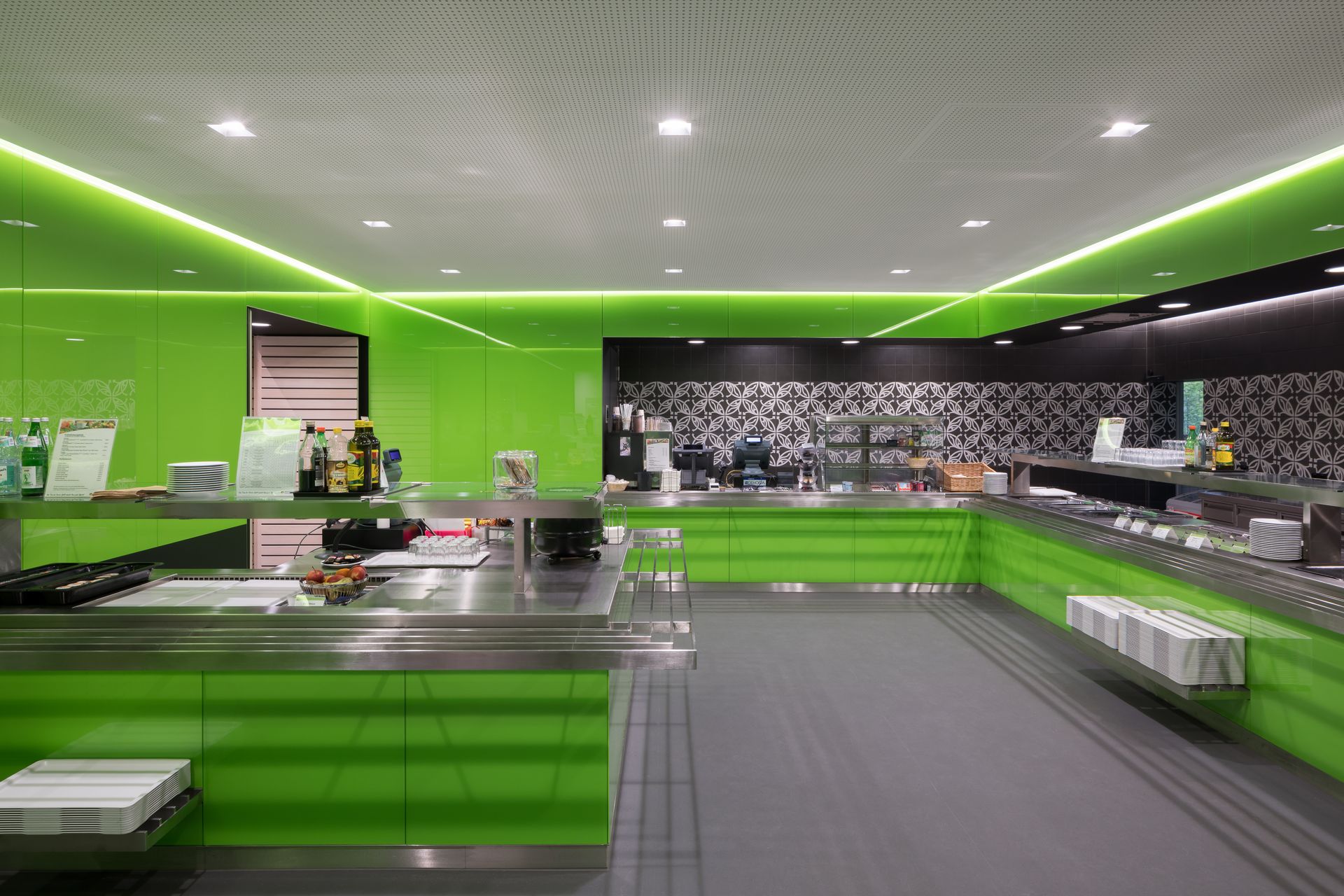 Ein Buffet in einem Restaurant mit grünen Wänden und Theken aus Edelstahl.