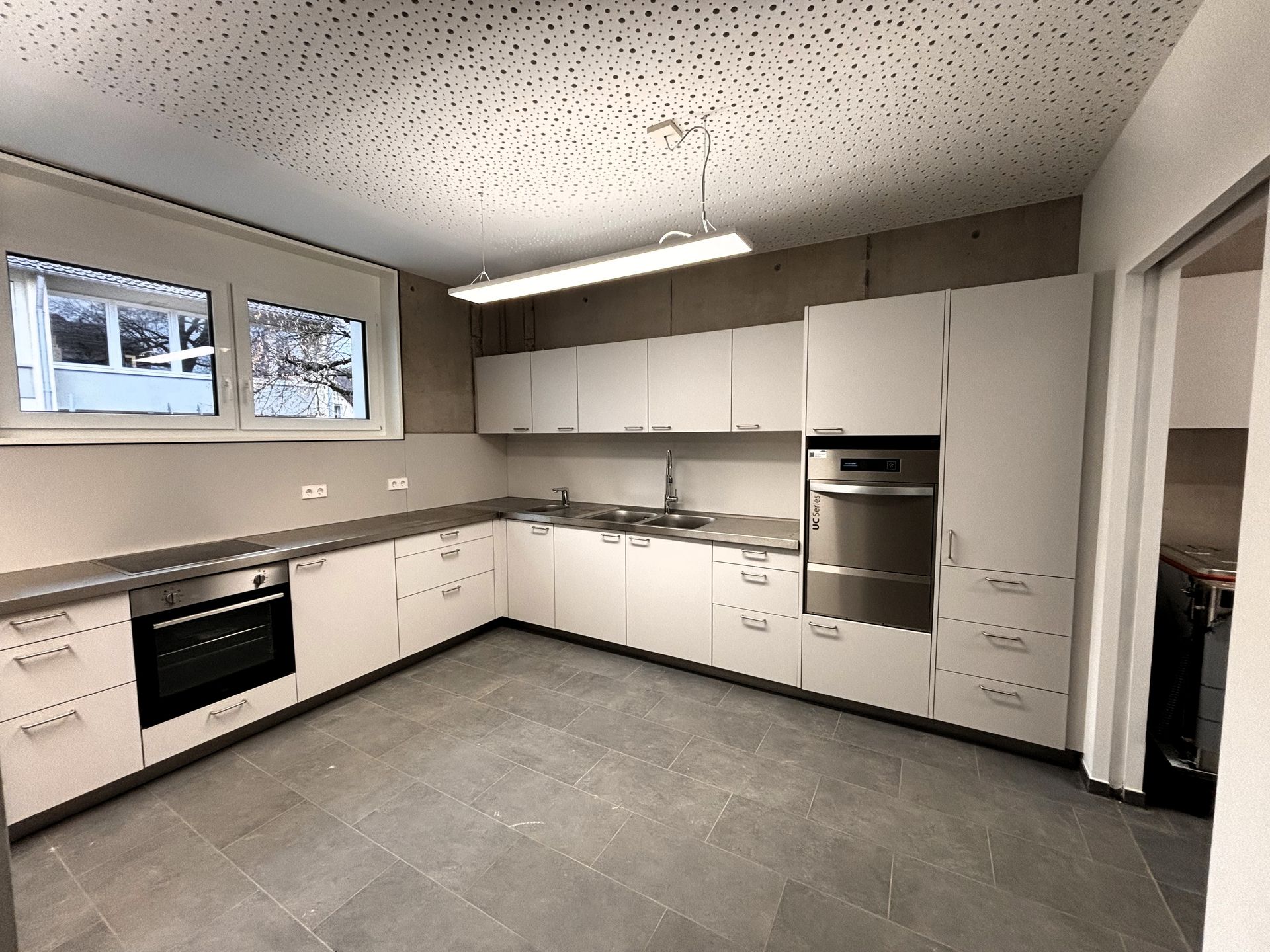 Eine Küche mit weißen Schränken und Geräten aus Edelstahl