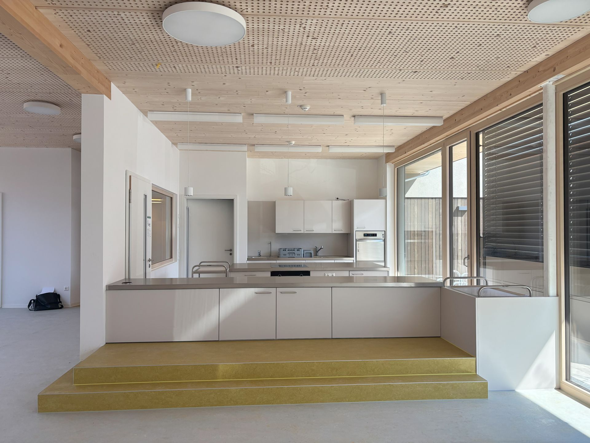 Eine Küche mit weißen Schränken und einer Holzdecke