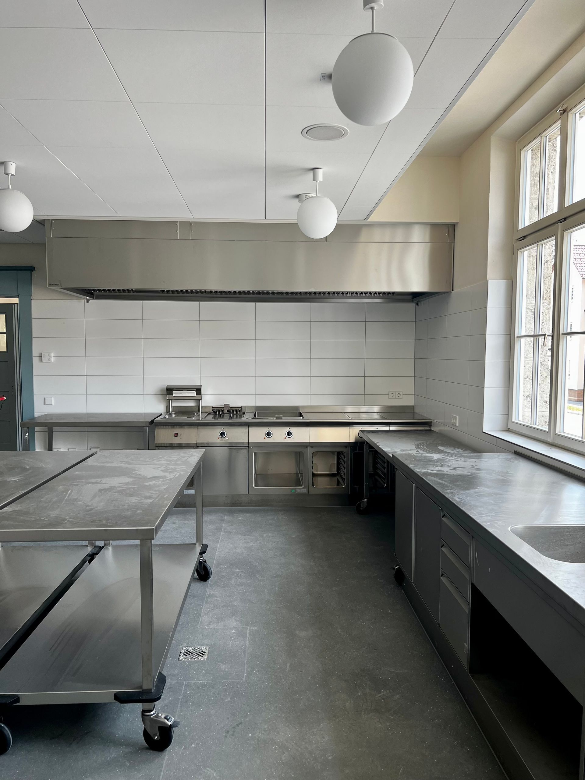 Eine leere Küche mit Edelstahl-Arbeitsplatten und einem Herd