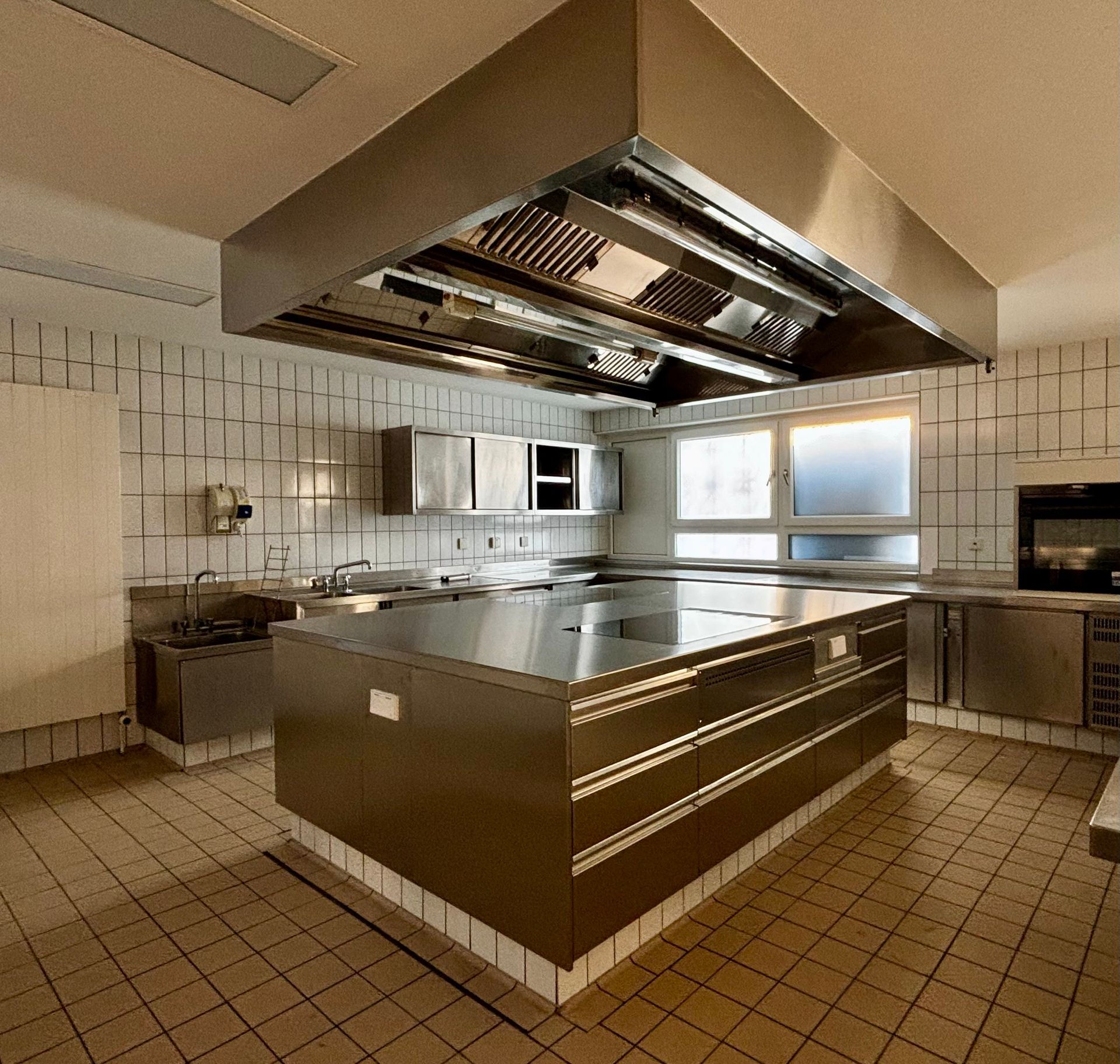 Eine Küche mit Edelstahlschränken und einer großen Insel