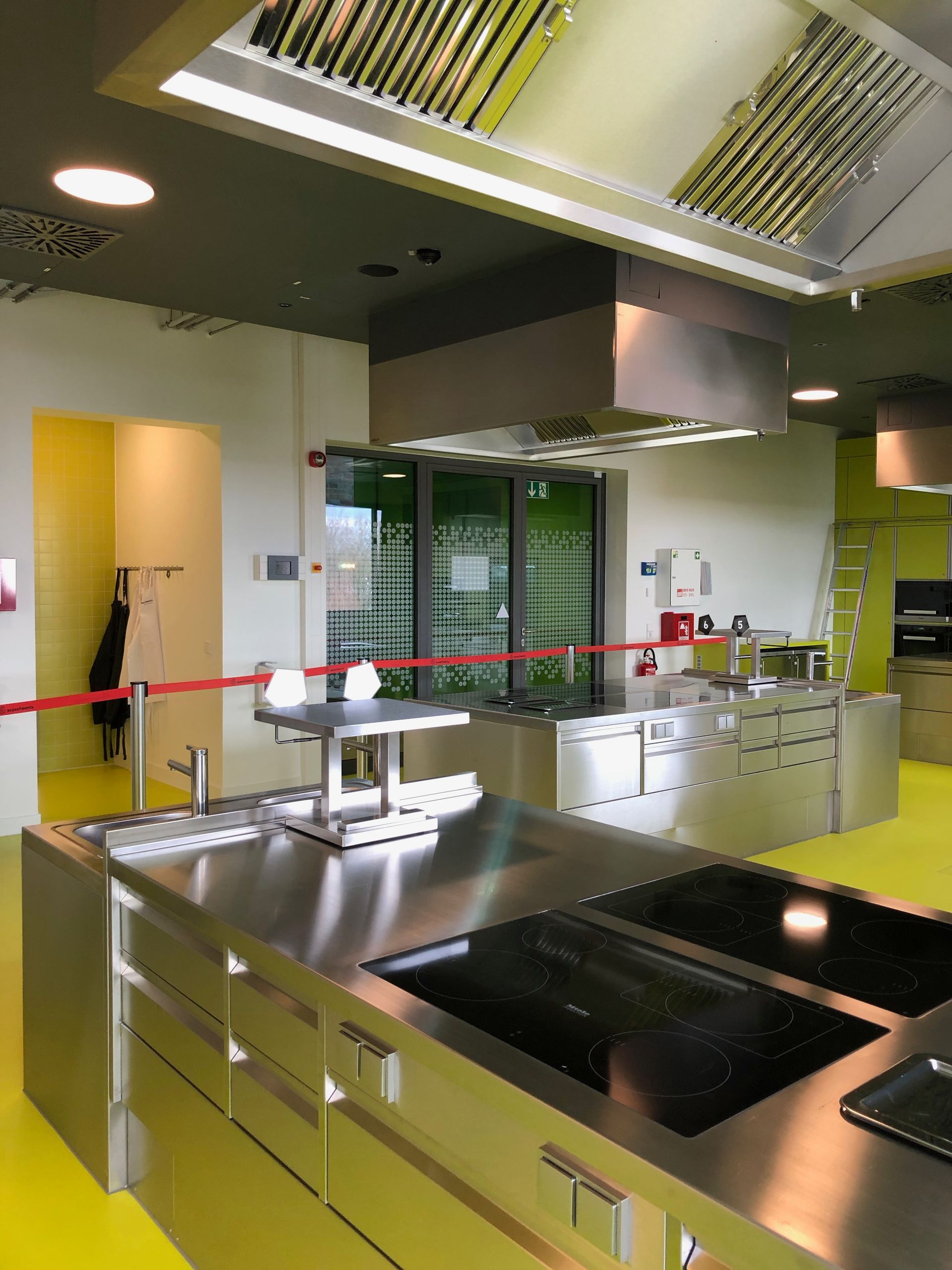 Eine Küche mit Geräten aus Edelstahl und einem gelben Boden