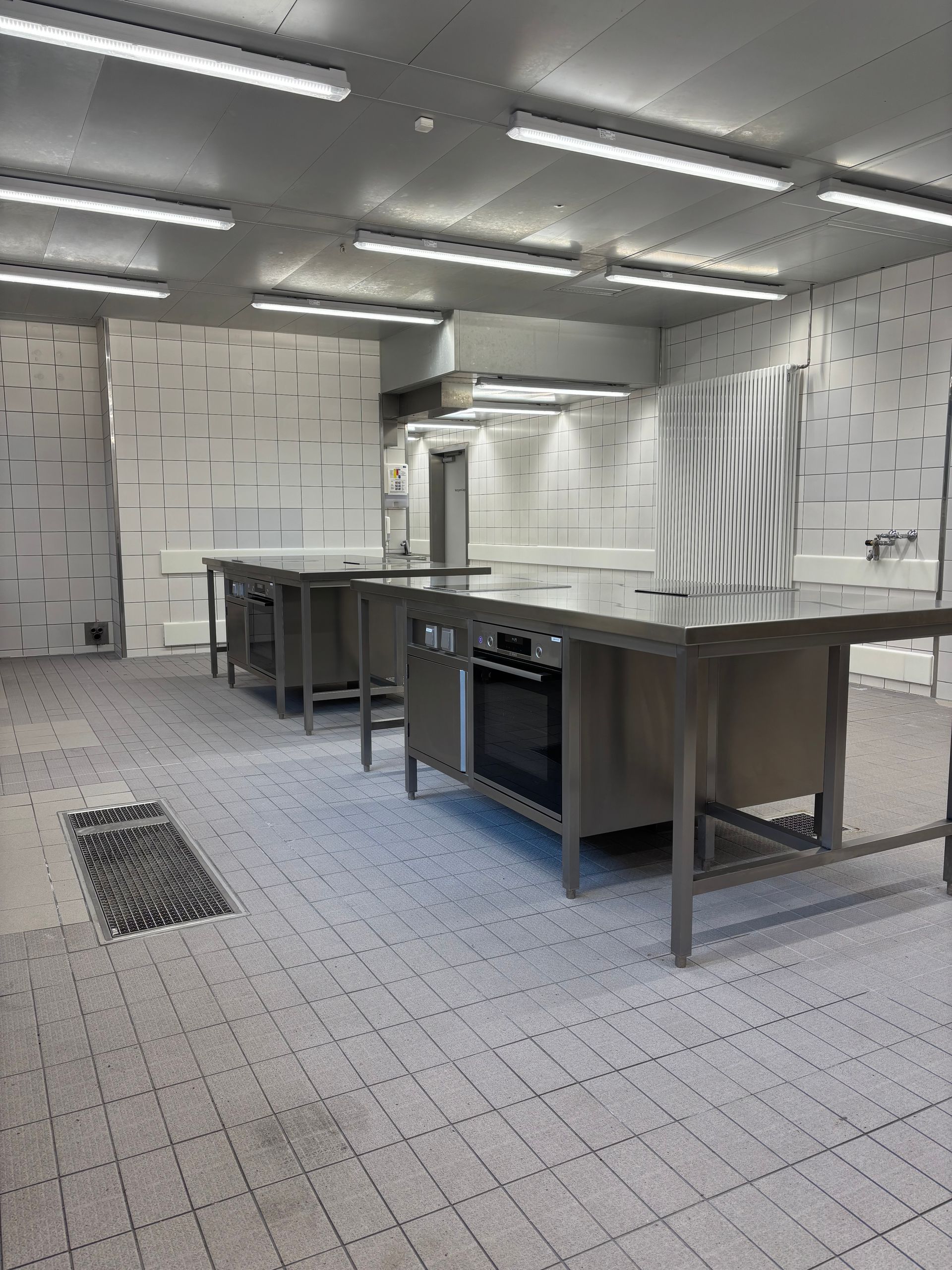 Eine große Küche mit Tischen und Geräten aus Edelstahl