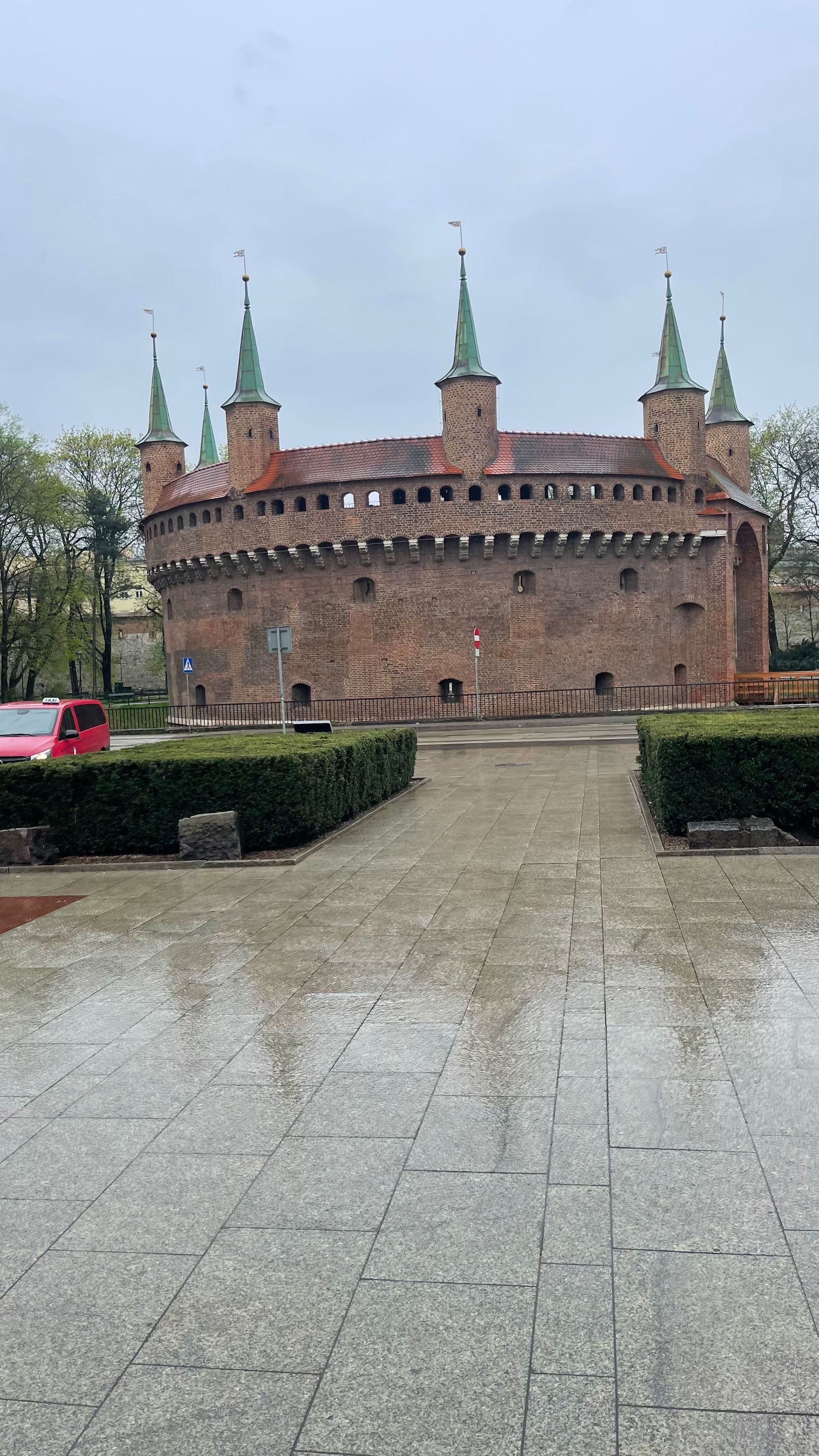 Brick Barbican fortress with multiple turrets, in Krakow, Poland. Gray, rainy day.