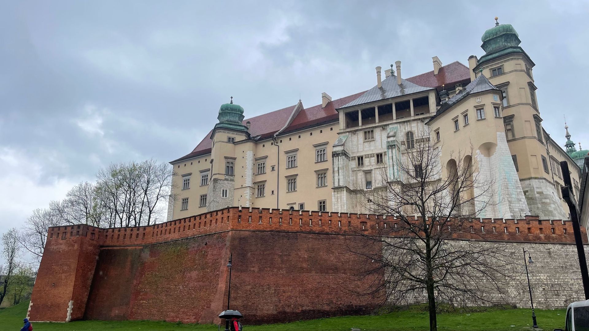 Wawel Castle in Krakow, Poland, with brick walls and towers under an overcast sky.