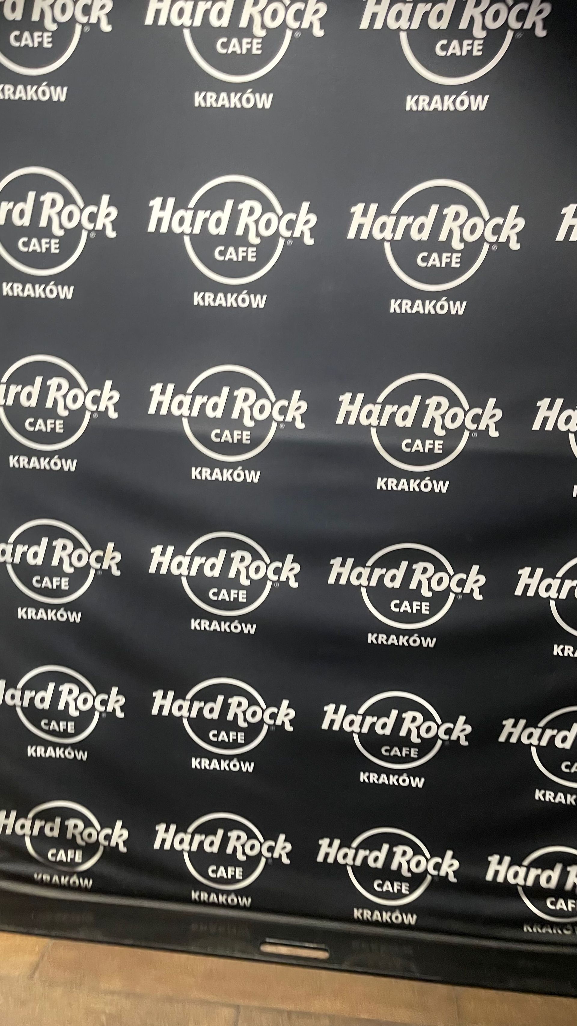 Black Hard Rock Cafe backdrop with white logos in Kraków, Poland.