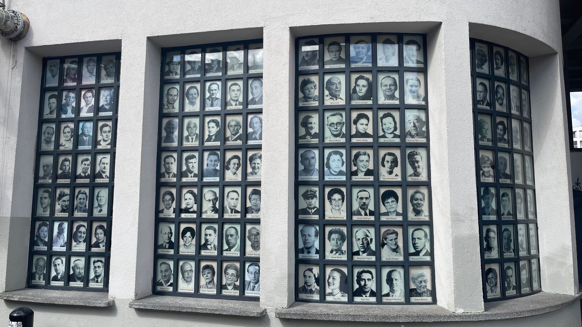 Windows displaying numerous black and white portraits, likely commemorating individuals.