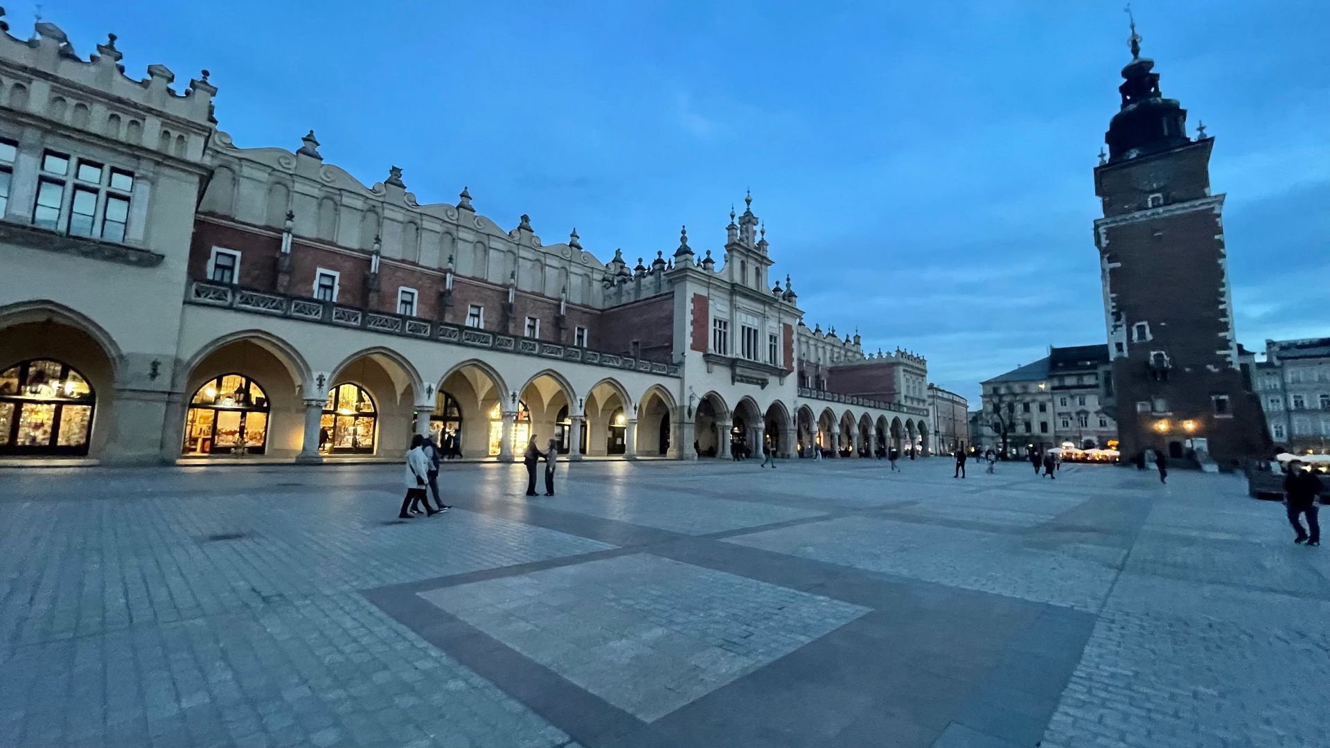 Cloth Hall and Town Hall Tower in Krakow's main square, at dusk.