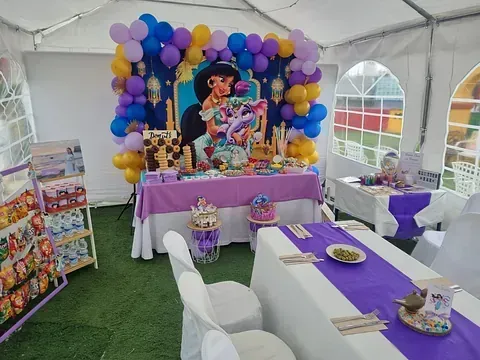 Una carpa con una mesa y sillas instalada para una fiesta de cumpleaños.