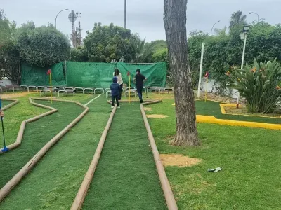 Un grupo de personas está jugando al minigolf en un parque.