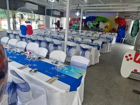 Una gran sala con mesas y sillas preparadas para una fiesta.