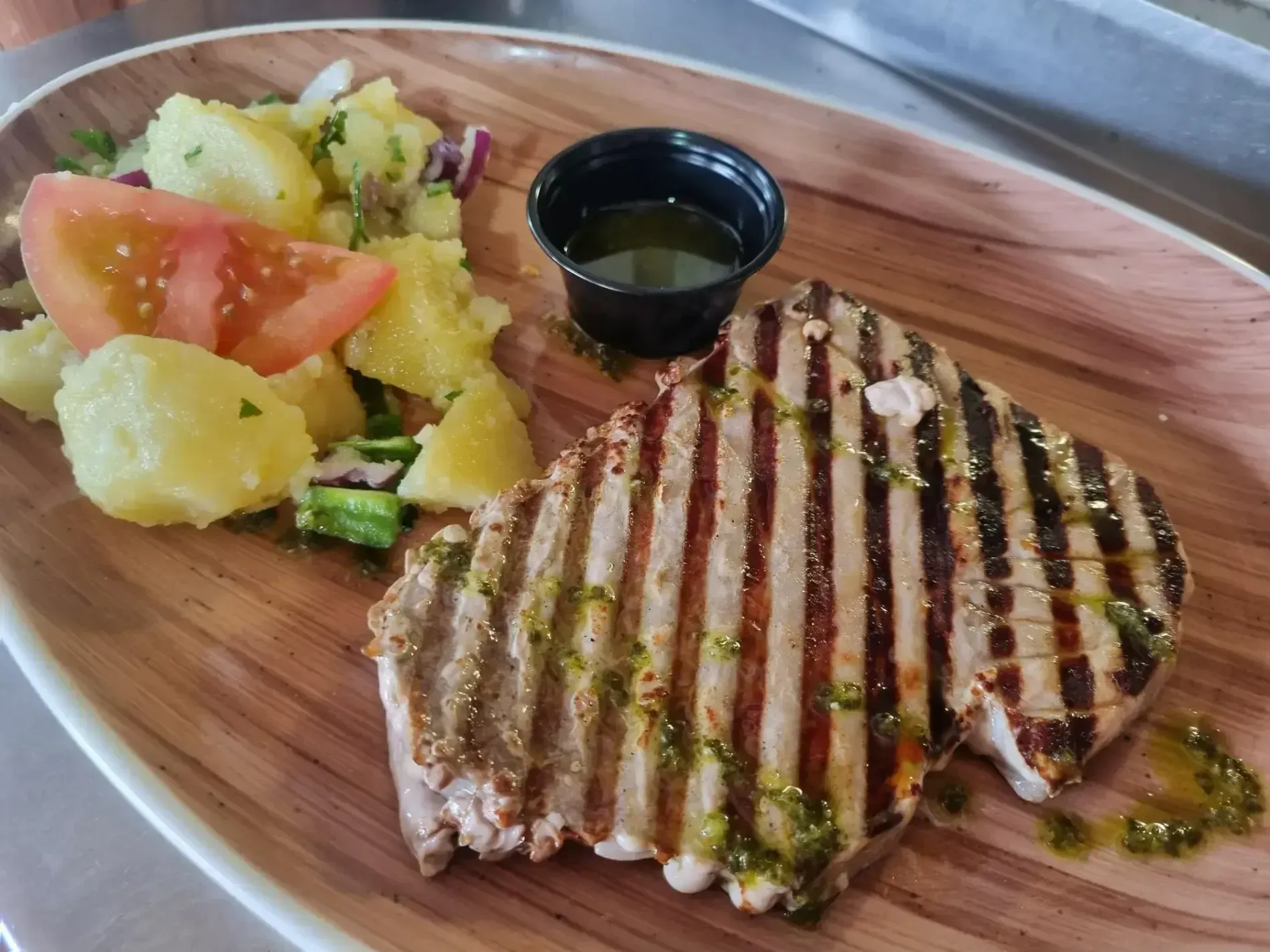 Un plato de comida con carne y patatas encima.