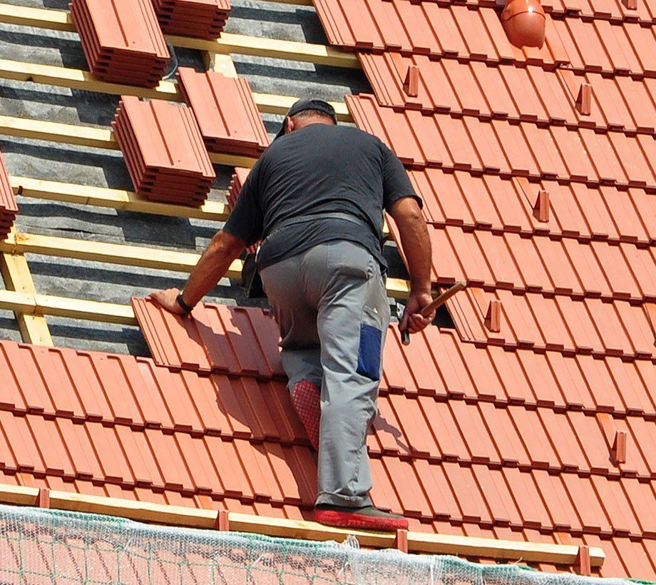 Ouvrier sur une toiture posant des tuiles