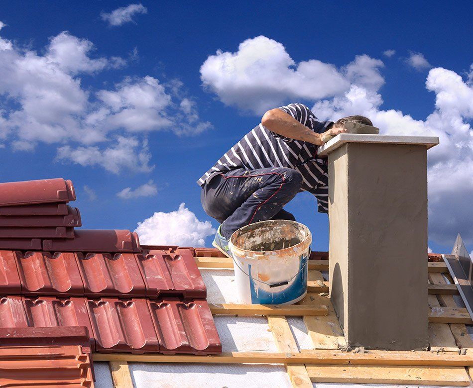 Un artisan répare une cheminée de toit