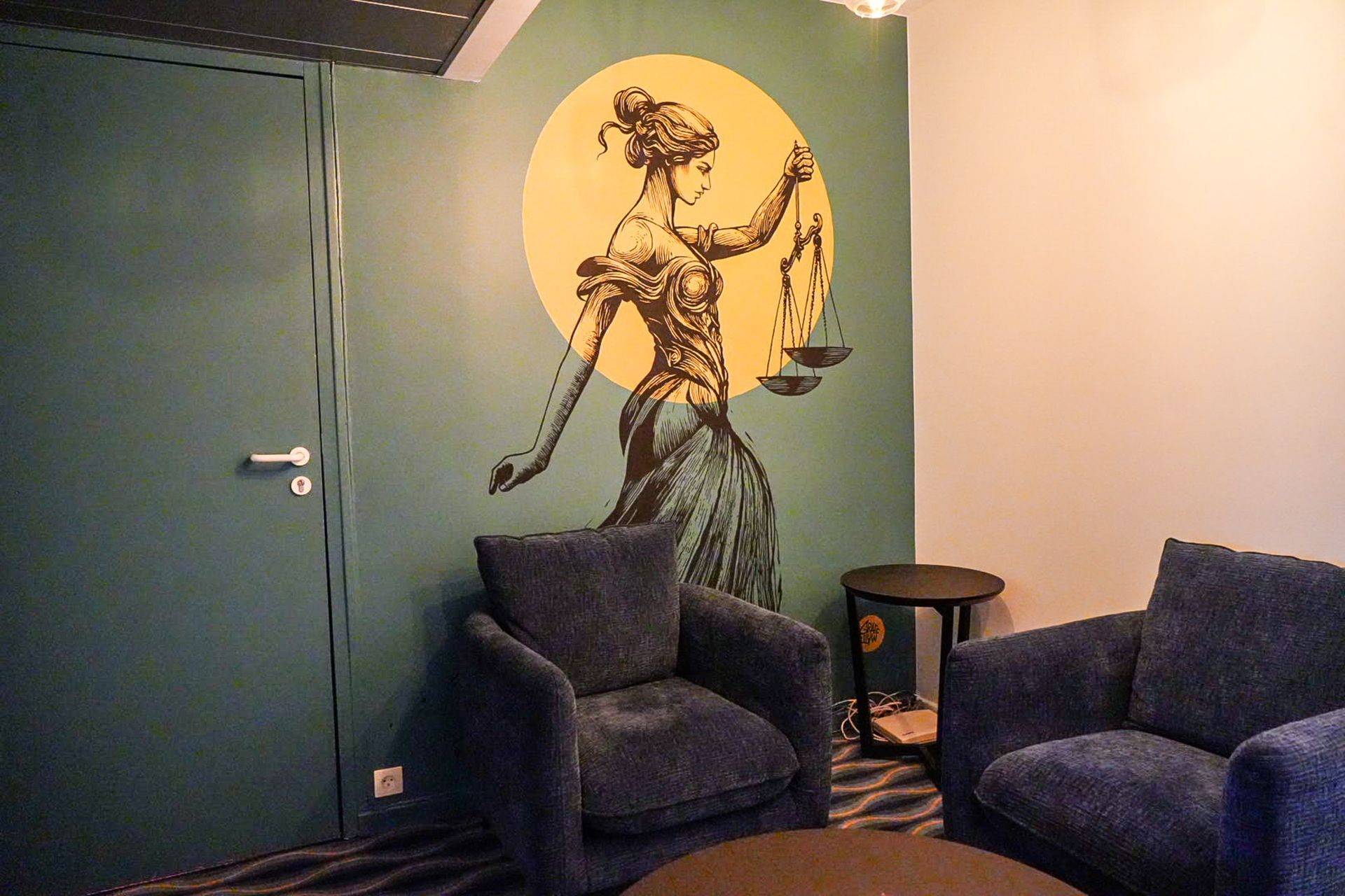 L'intérieur de la salle d'attente du cabinet d'avocats avec une fresque de la balance de la justice.