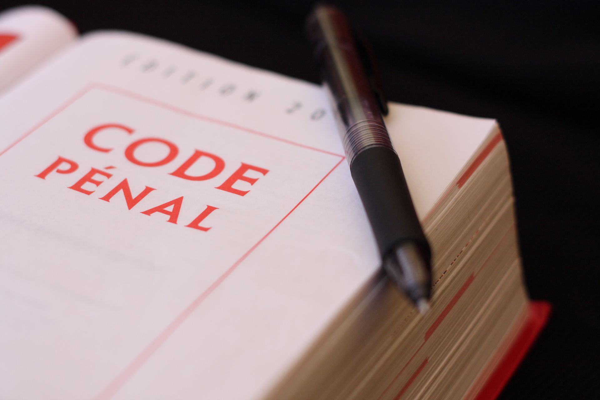 Gros plan sur un Code pénal ouvert avec un stylo.