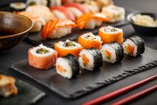 Assortiment de sushis et makis présentés sur une ardoise.