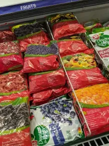 Présentation du rayon surgelés : gros plan sur les sachets de fruits et légumes surgelés.