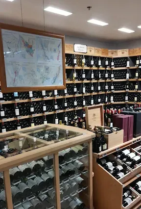 Présentation de la Cave à vins : bouteilles de vin rangées sur des étagères en bois.