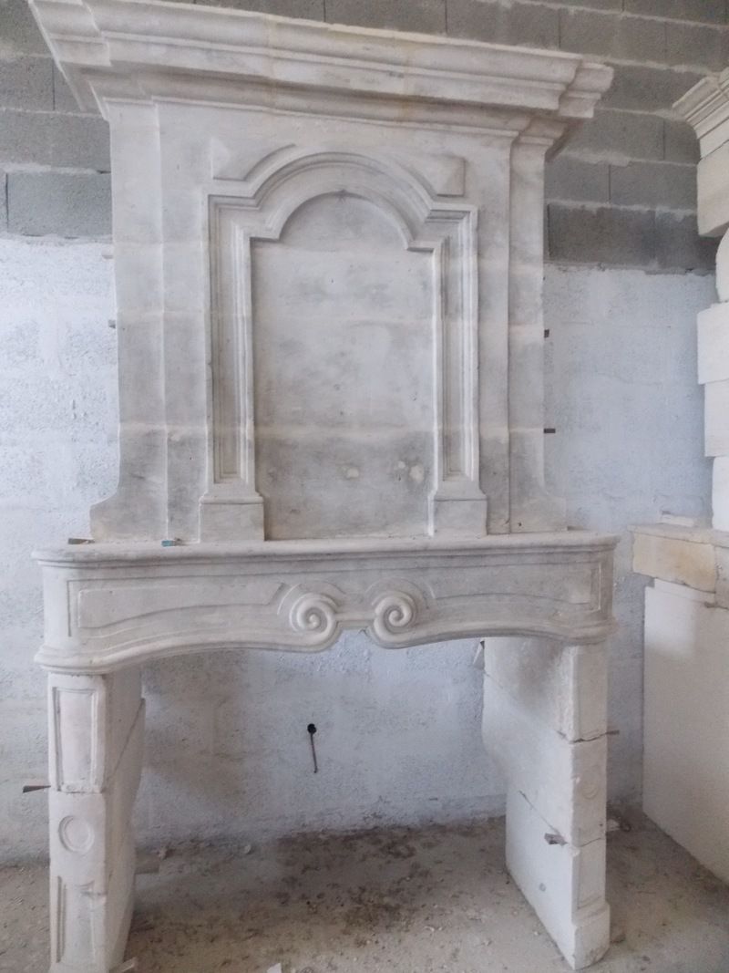 Cheminée en pierre ornée de sculptures.