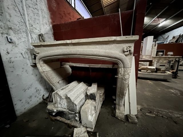 Une cheminée en pierre brisée dans un espace de rangement intérieur. Beige avec des murs rouges et gris.
