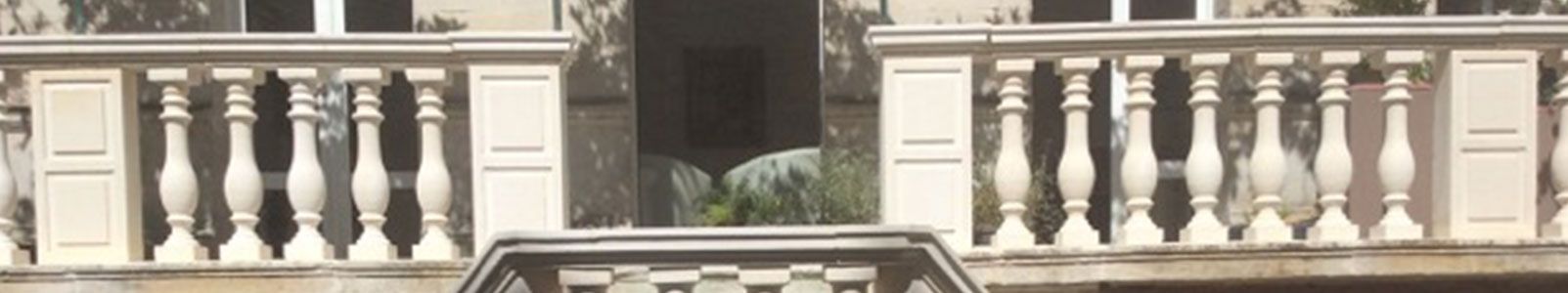 Balustrade et façade du bâtiment. Balustres blancs ouvragés, architecture en pierre.