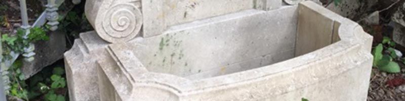 Fontaine en pierre avec un motif en spirale et un bassin octogonal.