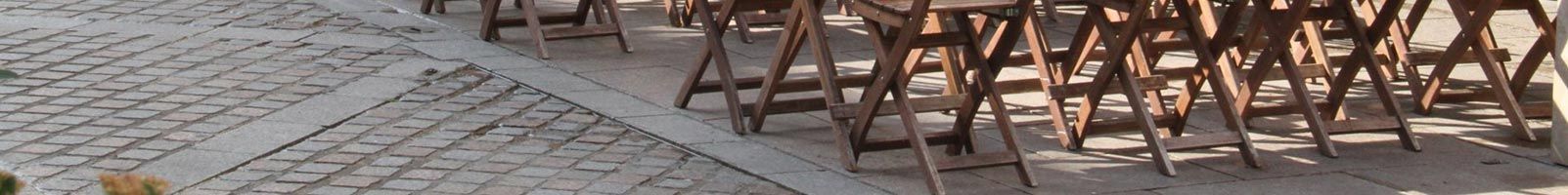 Des rangées de chaises dorées sur une surface pavée.