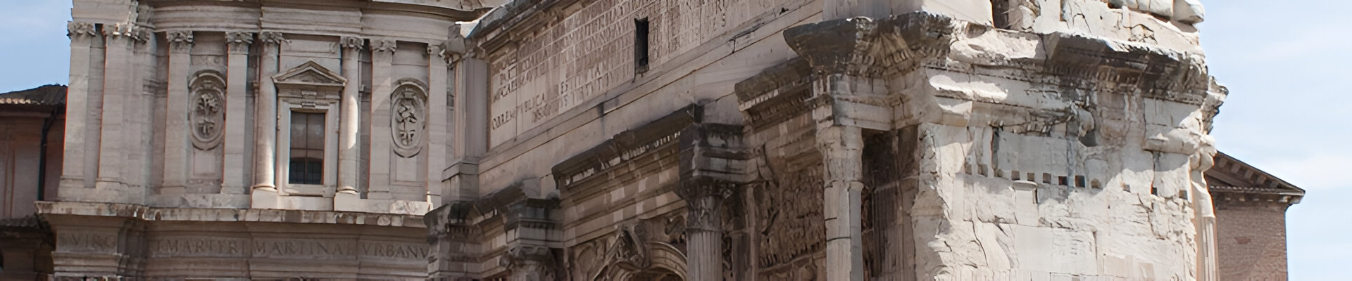 Ancien bâtiment en pierre aux sculptures détaillées se détachant sur un ciel bleu.