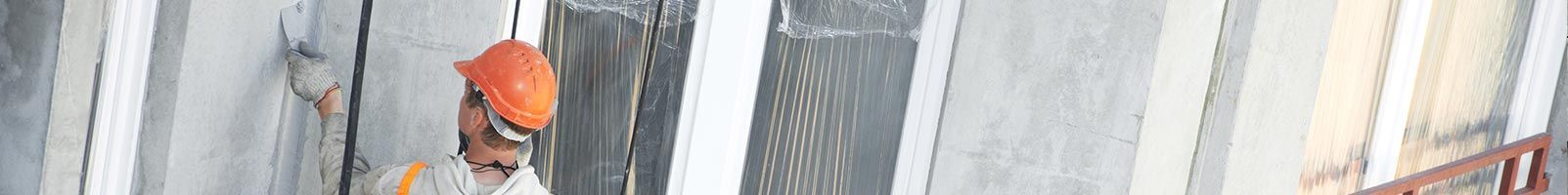 Chantier de construction avec des murs gris et un objet orange.