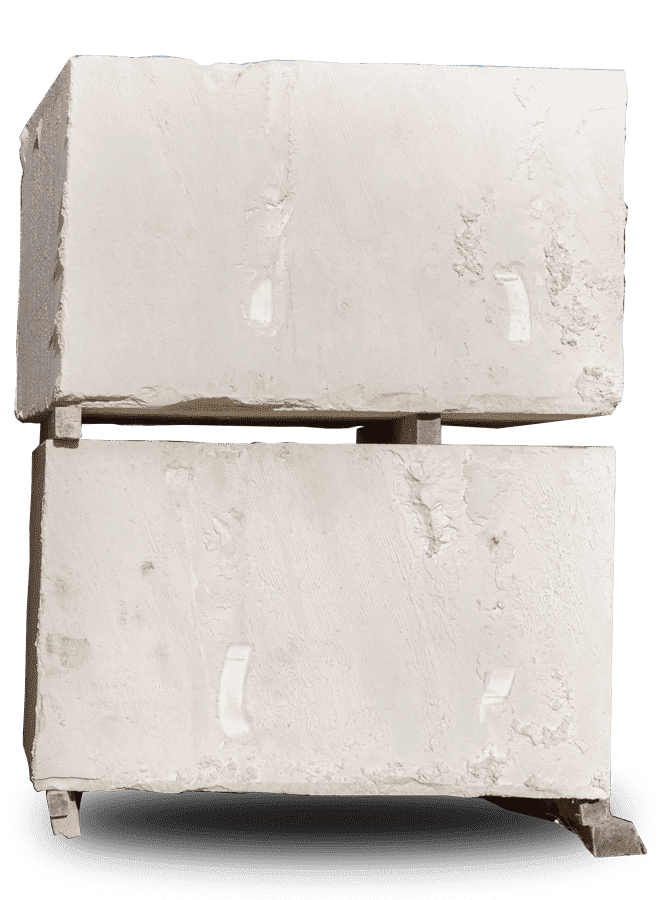 Deux blocs de béton gris clair empilés sur un socle en bois, projetant une ombre.