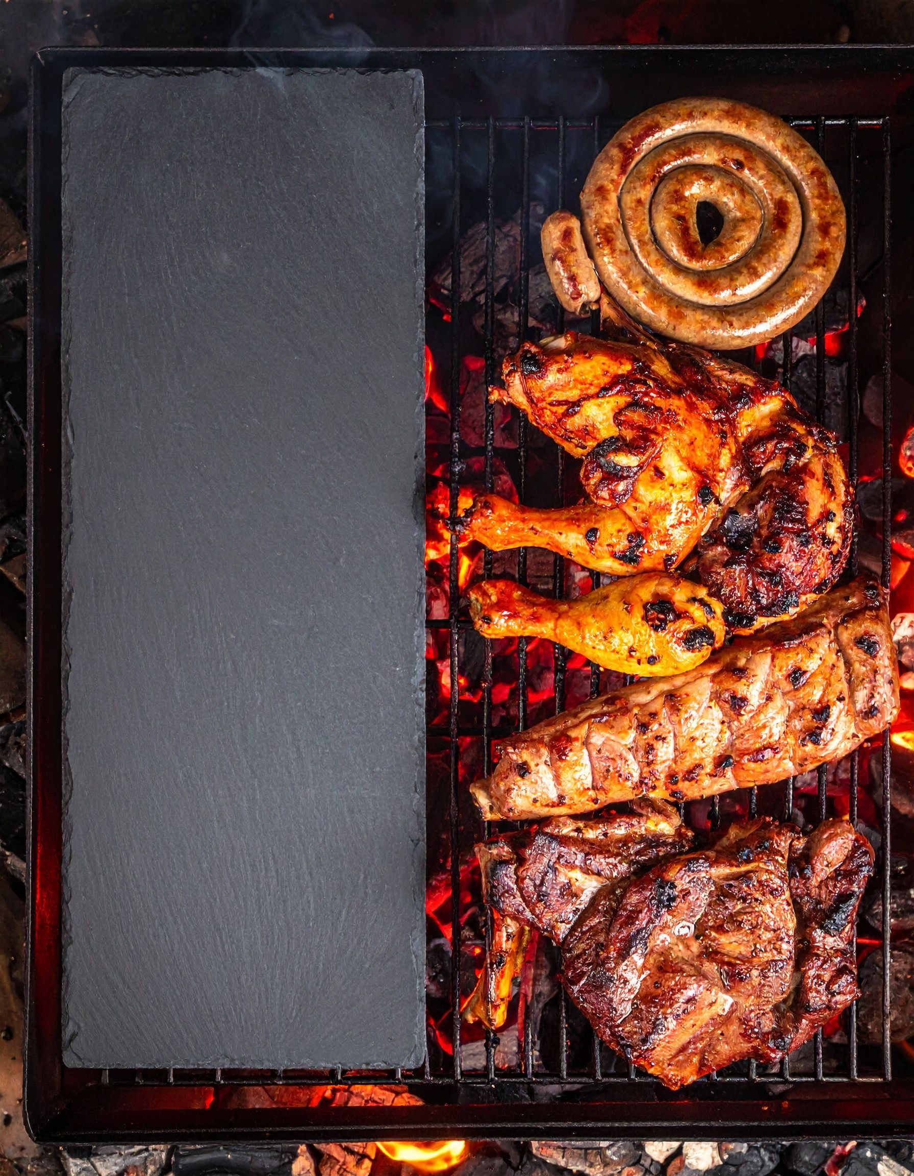 Poulet grillé, saucisse et côtes levées sur un barbecue chaud, avec une ardoise vierge à gauche.