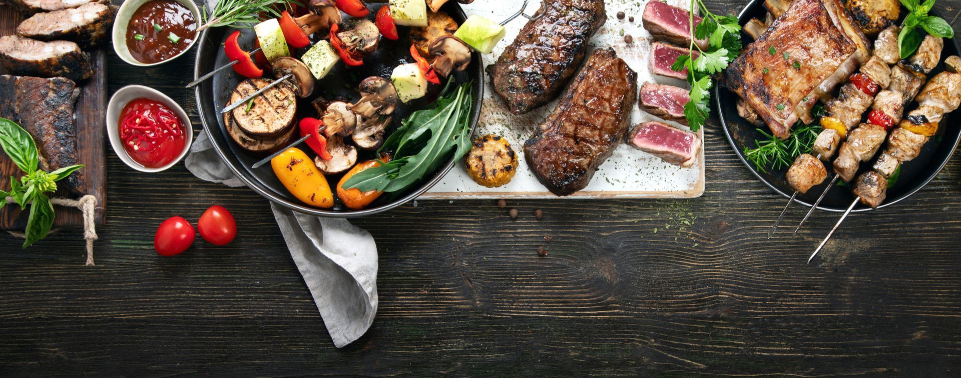 Viandes et légumes grillés sur une table en bois rustique.